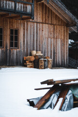 Sticker - Chopped wooden logs in front of a house with snow