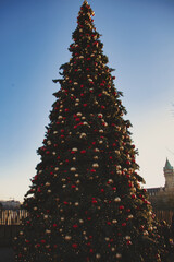 Poster - Vertical shot of the big Christmas tree decorated with different toy balls outdoors