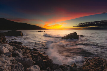 Wall Mural - Scenic view of a rocky beach during sunset