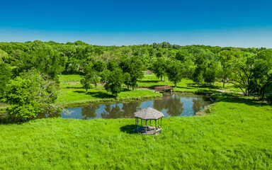 Sticker - Beautiful view of a small lake among bright green field and forest