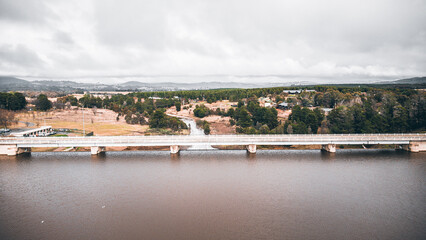 Wall Mural - Bridge over reservoir with cloudy sky on the background