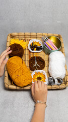 Poster - Portrait of a pair of hands reaching for knitting materials in a small basket