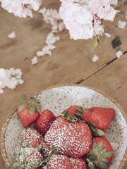 Poster - Vertical shot of strawberries in a bowl on a wooden table