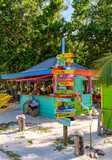 Colorful sign post in front of a tropical beach bar.