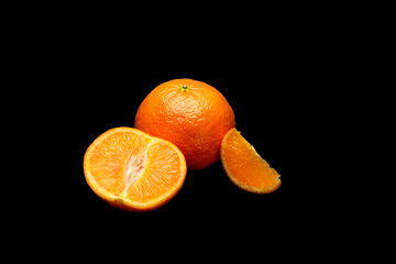 Sticker - Ripe orange and slices isolated on a black background