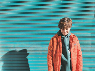 Wall Mural - Handsome teenager posing happily in an orange jacket