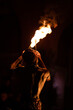 Back shot of a performer Moroccan fire breather, in Marrakech at night