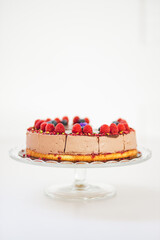 Wall Mural - Vertical closeup of the chocolate cheesecake with raspberries and blueberries on top.