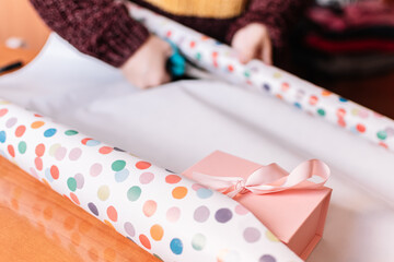 Sticker - Unrecognizable woman wrapping and decorating a Christmas gift. Concept of Christmas and Mother's Day