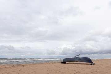 Canvas Print - Closeup of a canoe upside down on the sandy beach in a cloudy weather