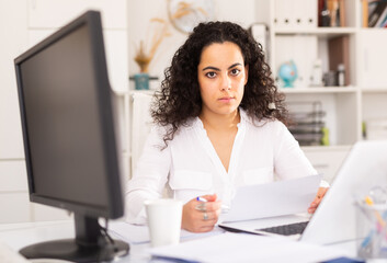 Wall Mural - Confident businesswoman in formal wear working on laptop in business office