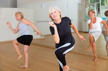 Group Of Three Mature Women Performing Modern Dance In Exercise Room.