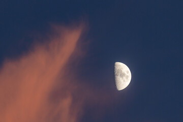 Wall Mural - closeup of a half moon at sunset with red clouds