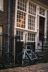 Sticker - Vertical shot of bicycles leaning on a gate along the street