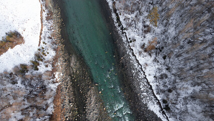 Poster - Bird's eye view of a river in a winter forest in Switzerland