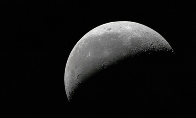 Wall Mural - Half full gray moon in a dark black sky
