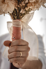 Poster - Selective focus portrait of a flower bouquet held by a groom