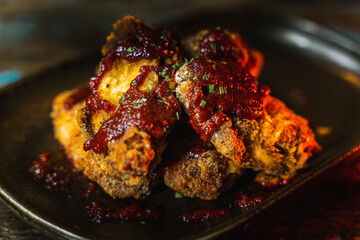 Poster - Tasty chicken wings dish in a dark grungy restaurant setting