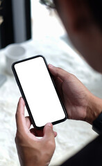 Wall Mural - young man holding mockup smart phone with white blank screen for graphic display montage.