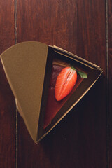 Wall Mural - Top view of a Strawberry cheesecake in a triangular cake box