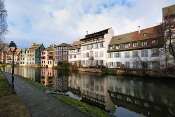 Wall Mural - Old houses in Strasbourg by the river under a blue cloudy sky on a sunny day