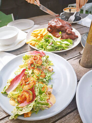 Wall Mural - Vertical shot of the dining table with seafood salad and BBQ ribs with French fries