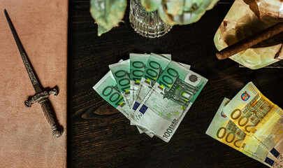 Poster - Hundred euro bills laid on a plush table with cigar and dagger