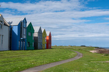Colorful Houses In John O'Groats Village Against A Cloudy Blue Sky