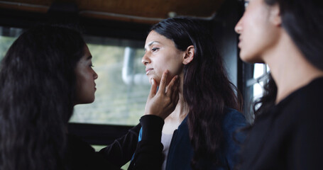 Canvas Print - Closeup shot of a  South Asian girl looking at two pretty two South Asian checking her face