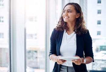 Wall Mural - Working smarter is always worth it. Shot of a young businesswoman using a digital tablet in an office.