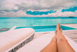 Luxury vacation swimming pool woman lounging relaxing sun tanning legs. Travel holiday summer people lifestyle. POV selfie of feet.