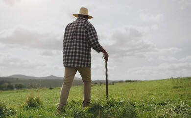 Poster - life on a farm, where less is best. rearview shot of a man working on a farm.