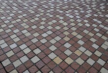 The Background Of The Rectangular Terracotta Tiles Is Arranged Alternately In Color For Beauty. Road Surface With Brown, White, Cream Patterns