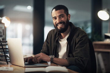 Poster - The tech that gets my designs done on time. Shot of a young businessman using a laptop during a late night at work.