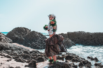 Wall Mural - hawaiian woman enjoys hula dancing on the beach barefoot wearing traditional costume