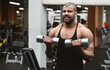 © ANR Production - Muscular afro-american man working out in gym doing exercises with dumbbells at shoulders without coach or instructor. Fitness crossfit bodybuilding concept