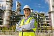 © Chanakon - Asian engineer manager woman with white safety helmet standing front of oil refinery. Industry zone gas petrochemical. Factory oil storage tank and pipeline. Workers in the refinery construction.