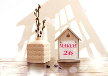 Calendar For March 26: A Decorative House With The Name Of The Month March In English, Numbers 26, A Bouquet Of Flowering Willow In A Vase, Window Shadow, Bokeh