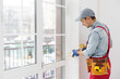 © Angelov - Construction worker putting sealing foam tape on window in house