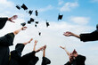 © xy - Graduating students hands throwing graduation caps in the air