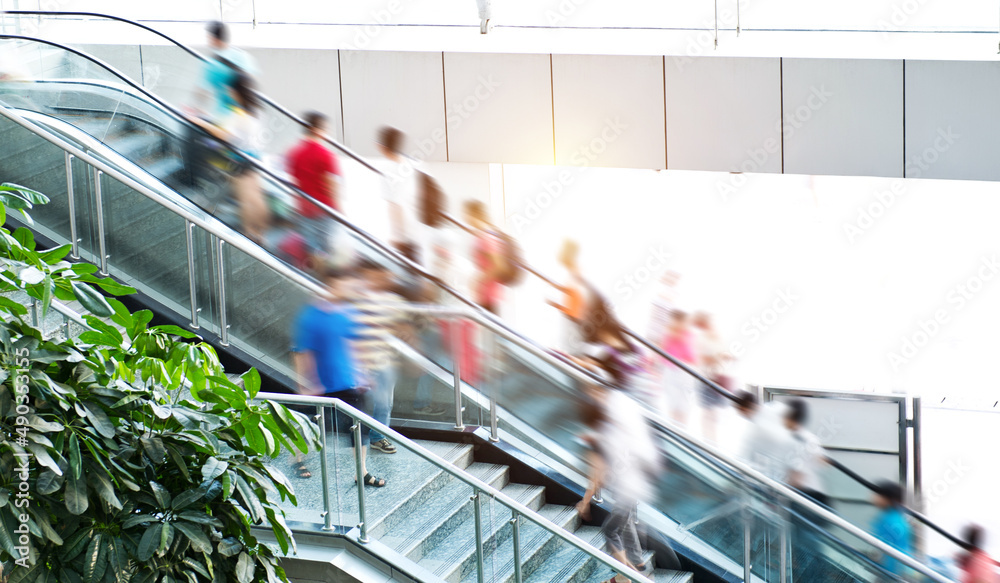 People rush on escalator motion blurred.