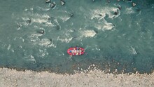 Above View Of Red Inflatable Boat Drifting Through Thresholds And Stones, Rafting On Mountain River. Aerial View From Drone Of Group Of People Rafting In Rubber Dinghy At Daytime. Concept Of Rafting