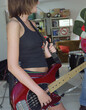 © SuperStock - Detail shot of young garage band bassist practicing with friend in garage