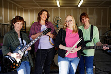 Portrait Of Garage Band Composed Of Middle Aged Women, Practicing In Residential Garage 