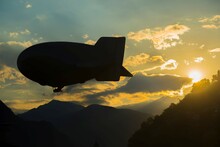 Blimp Flying Over The Mountain In Sunset In Locarno, Switzerland.