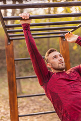 Wall Mural - Man working out on monkey bars in street workout park