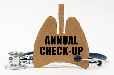 On a white surface are a stethoscope and a cardboard figure of a lung with the inscription - ANNUAL CHECK-UP