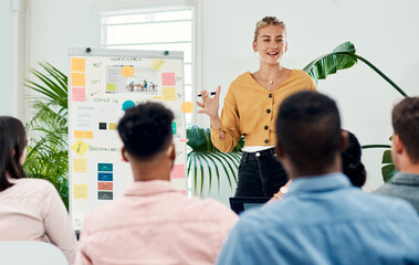 Poster - This is our new game plan. Cropped shot of an attractive young businesswoman standing and giving a presentation to her colleagues in the office.