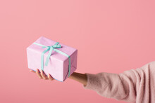 Cropped View Of Young Woman Holding Wrapped Gift Box Isolated On Pink.