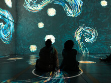 People Sitting In Physical Distancing Circles At Immersive Van Gogh Exhibit
